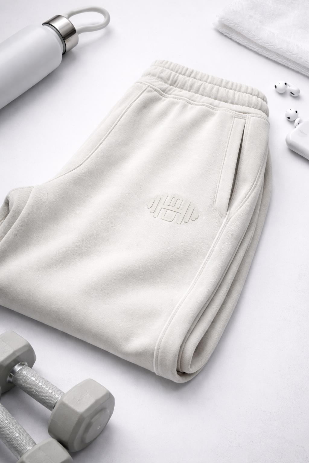 Detailopname van het Serene logo op een ivoorwitte rechtvallende damesbroek (straight fit) van luxe materiaal.