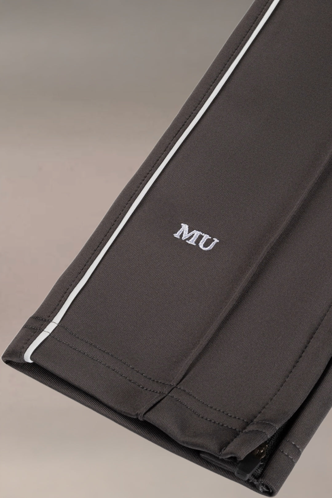 Detailshot van de broekspijp van zwarte heren sportbroek met witte zijstreep en subtiele afwerking, Muscle Up Store