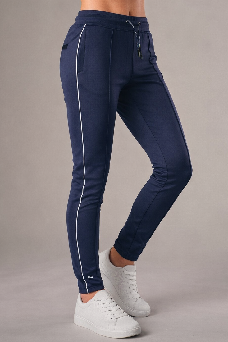 blauwe muscle fit sportbroek voor dames met witte zijstreep en embossed halterlogo, full body vooraanzicht, gedragen met wit T-shirt en witte sneakers