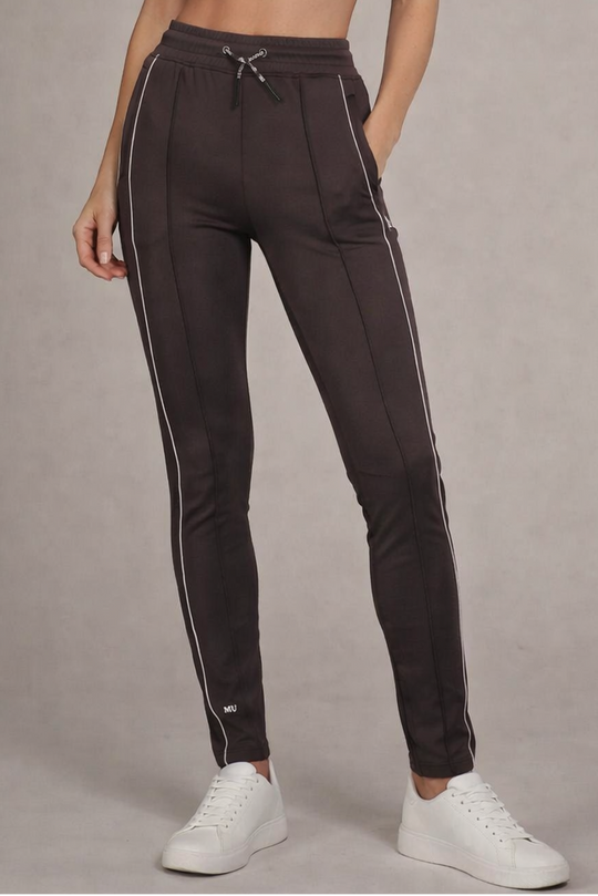Grijze muscle fit sportbroek voor dames met witte zijstreep en embossed halterlogo, full body vooraanzicht, gedragen met wit T-shirt en witte sneakers.