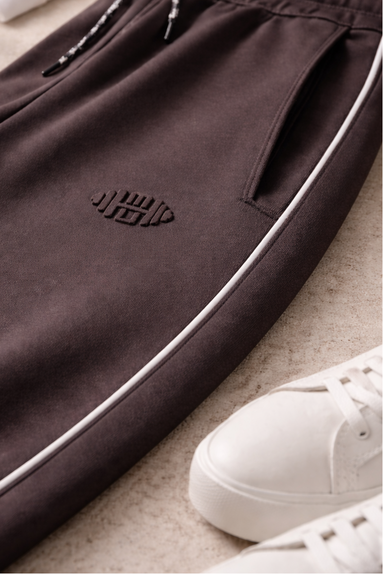 Close-up van een luxe sportbroek voor dames met subtiel logo in reliëf (embossed) voor een minimalistische uitstraling. grijs