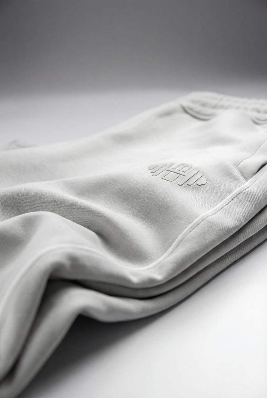 Close-up van de ivoorwitte stof van de 'Serene' straight pants voor heren, waarbij de fijne weving en de afwerking van de zakken zichtbaar zijn.