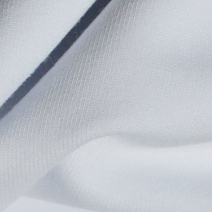 Close-up van hoogwaardig wit T-shirt stof, met zichtbare textuur en fijne weefstructuur voor een luxe en duurzame uitstraling.